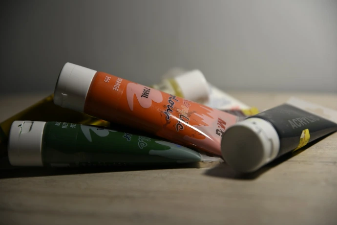 three tubes of toothpaste sitting on top of a wooden table
